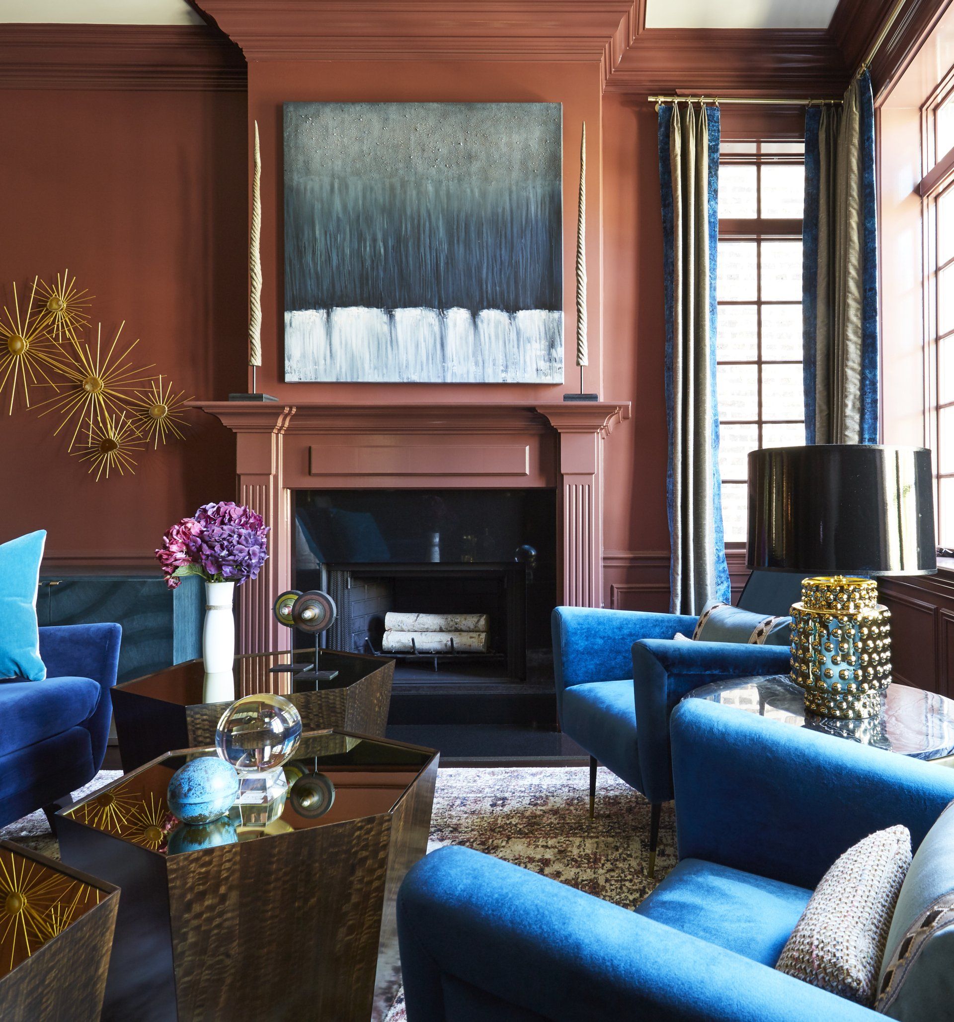 A living room with blue chairs and a fireplace
