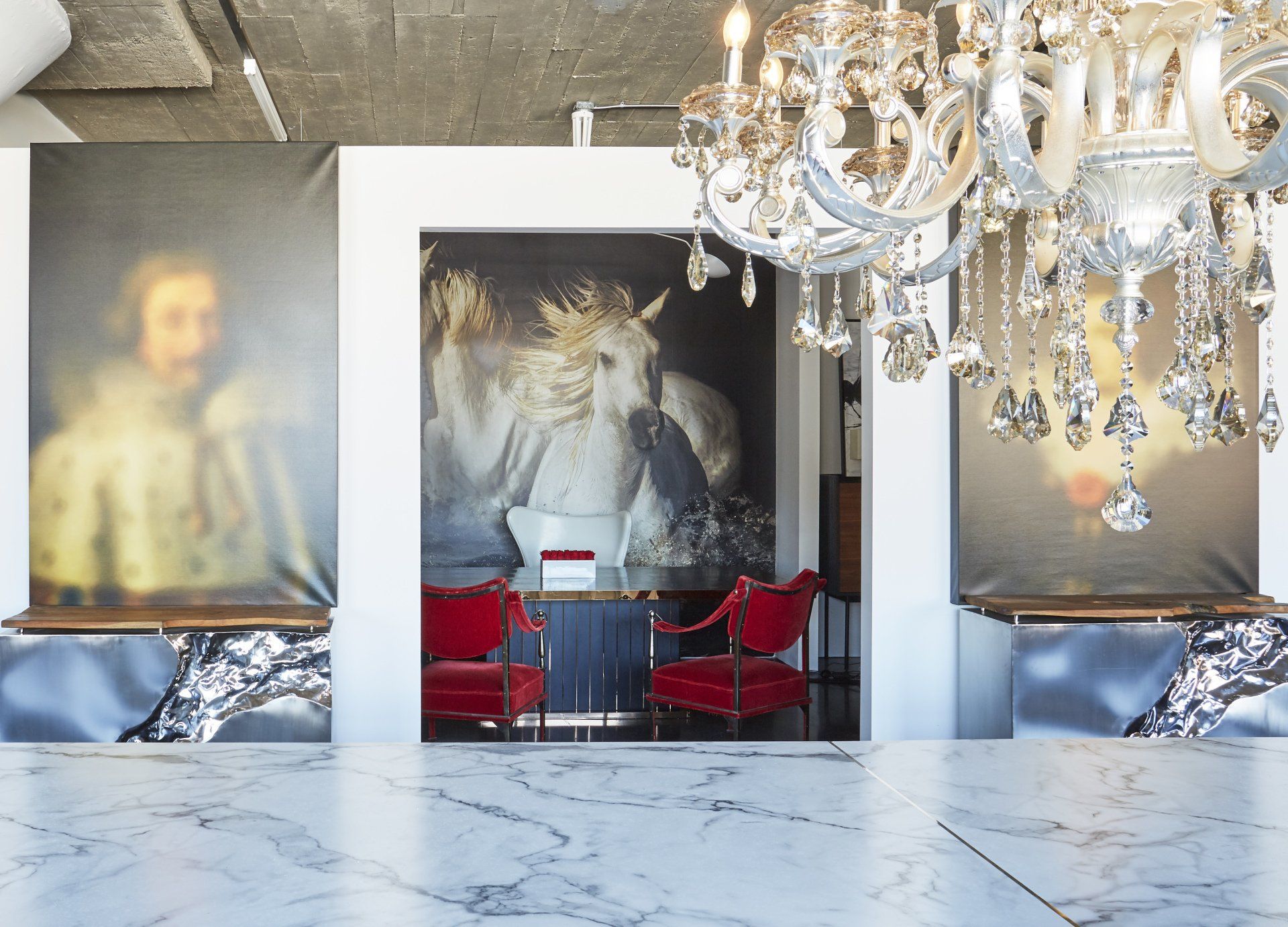 A room with a chandelier and a painting on the wall