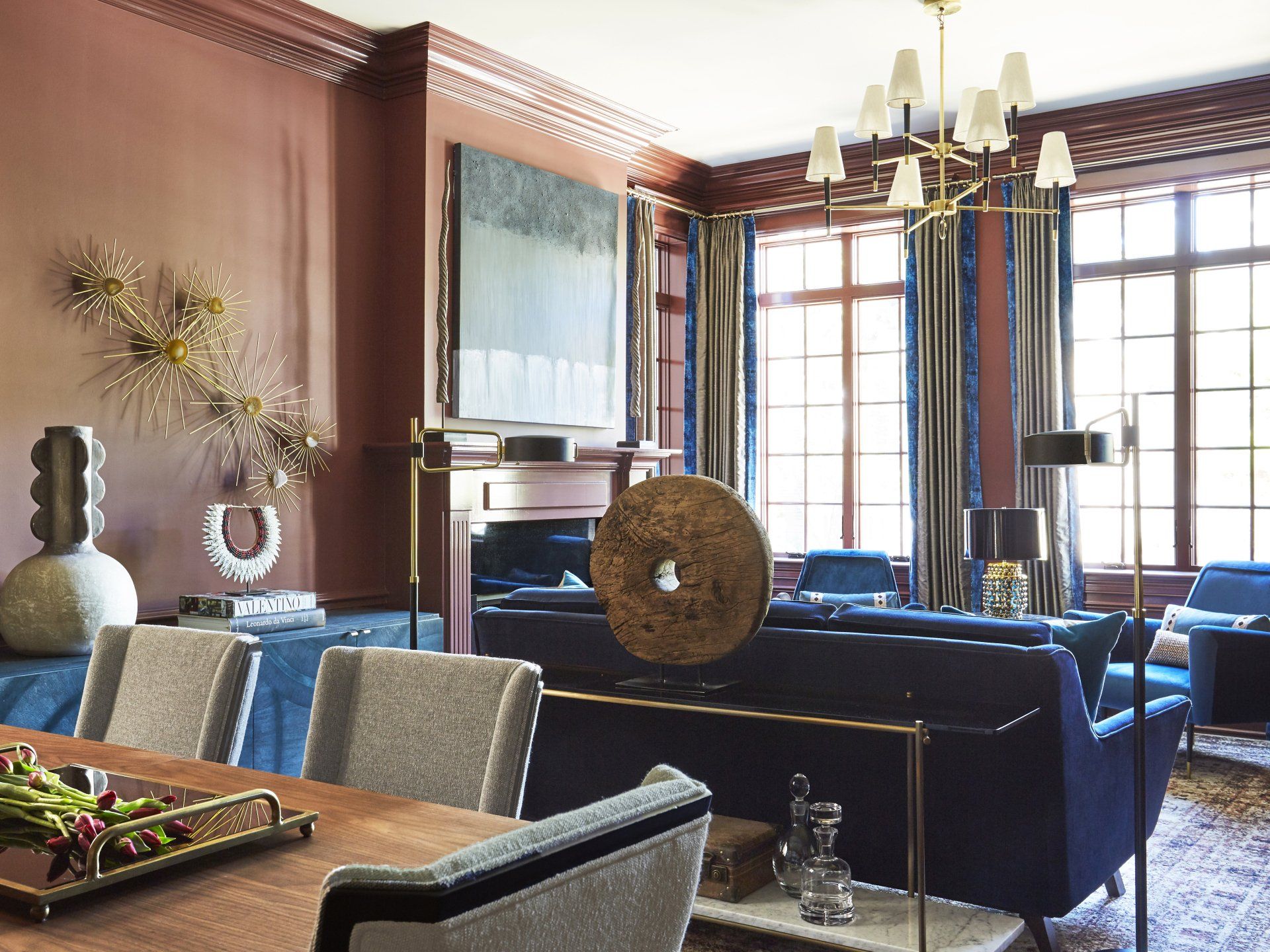 A living room with a couch , chairs , a table and a fireplace.