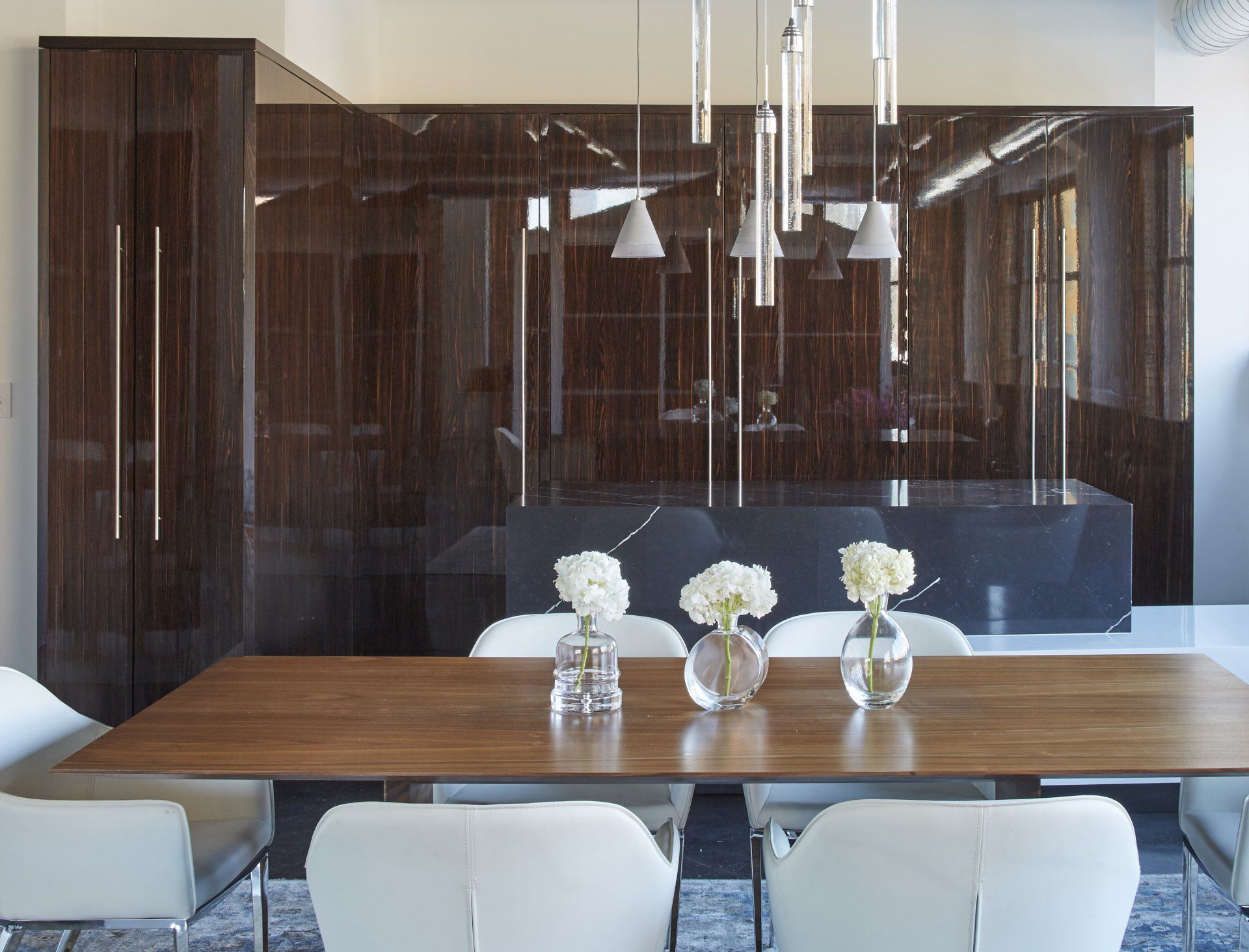 A dining room table with vases of flowers on it