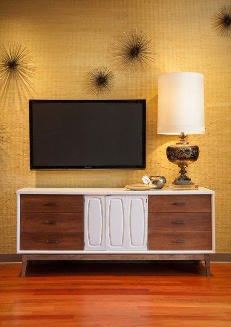 A living room with a television on the wall and a lamp.