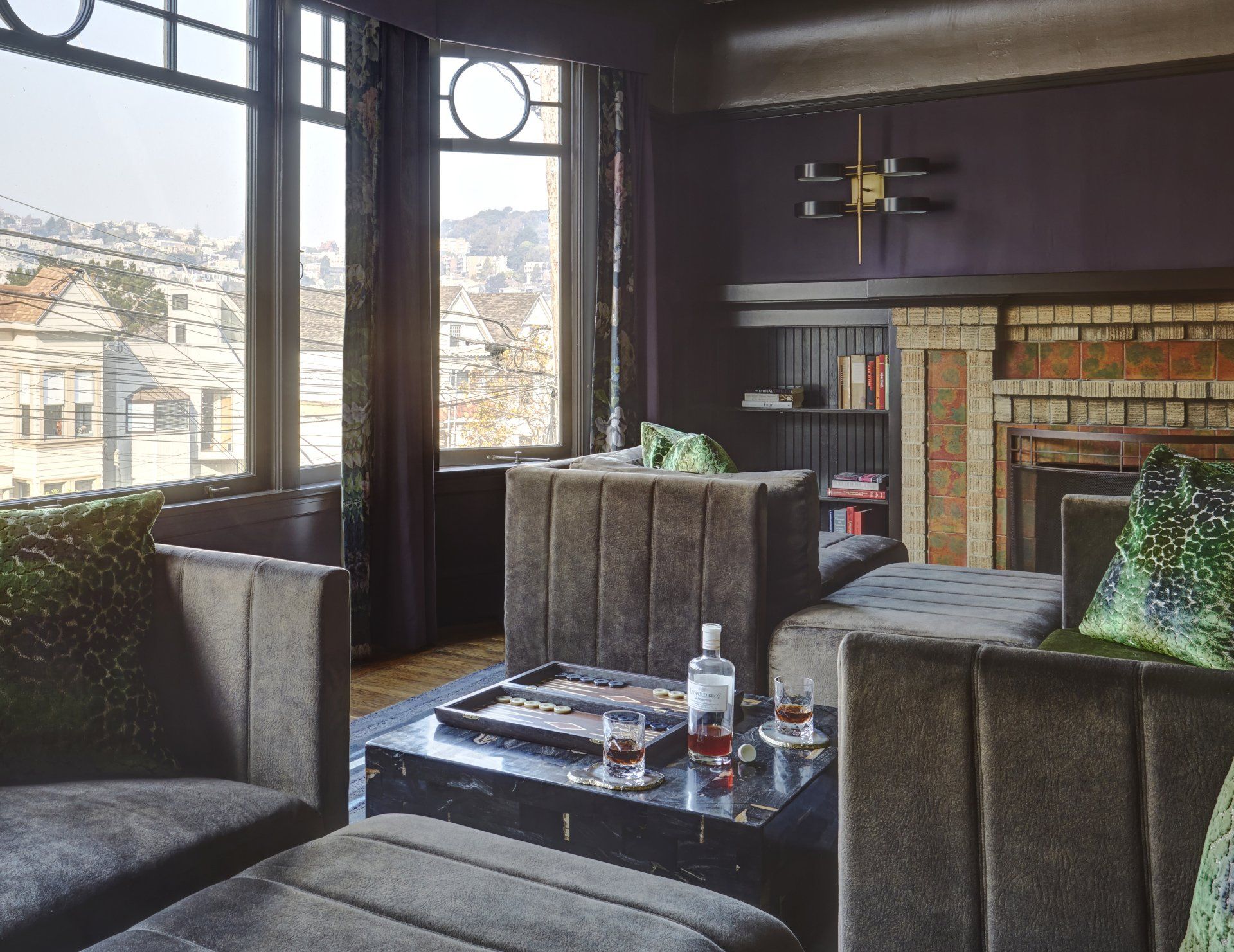 A living room with a couch and a table with a bottle of whiskey on it
