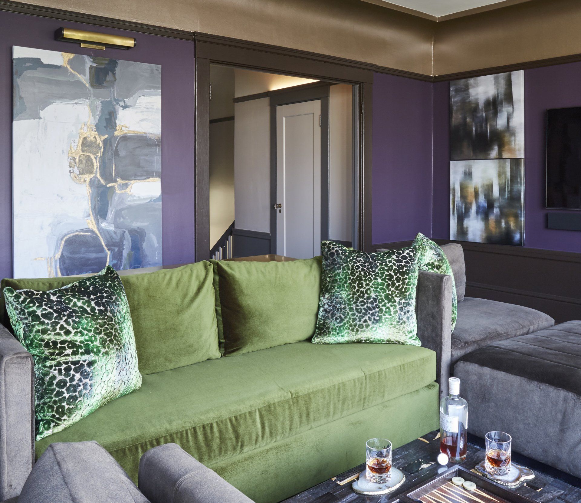 A living room with a green couch and purple walls