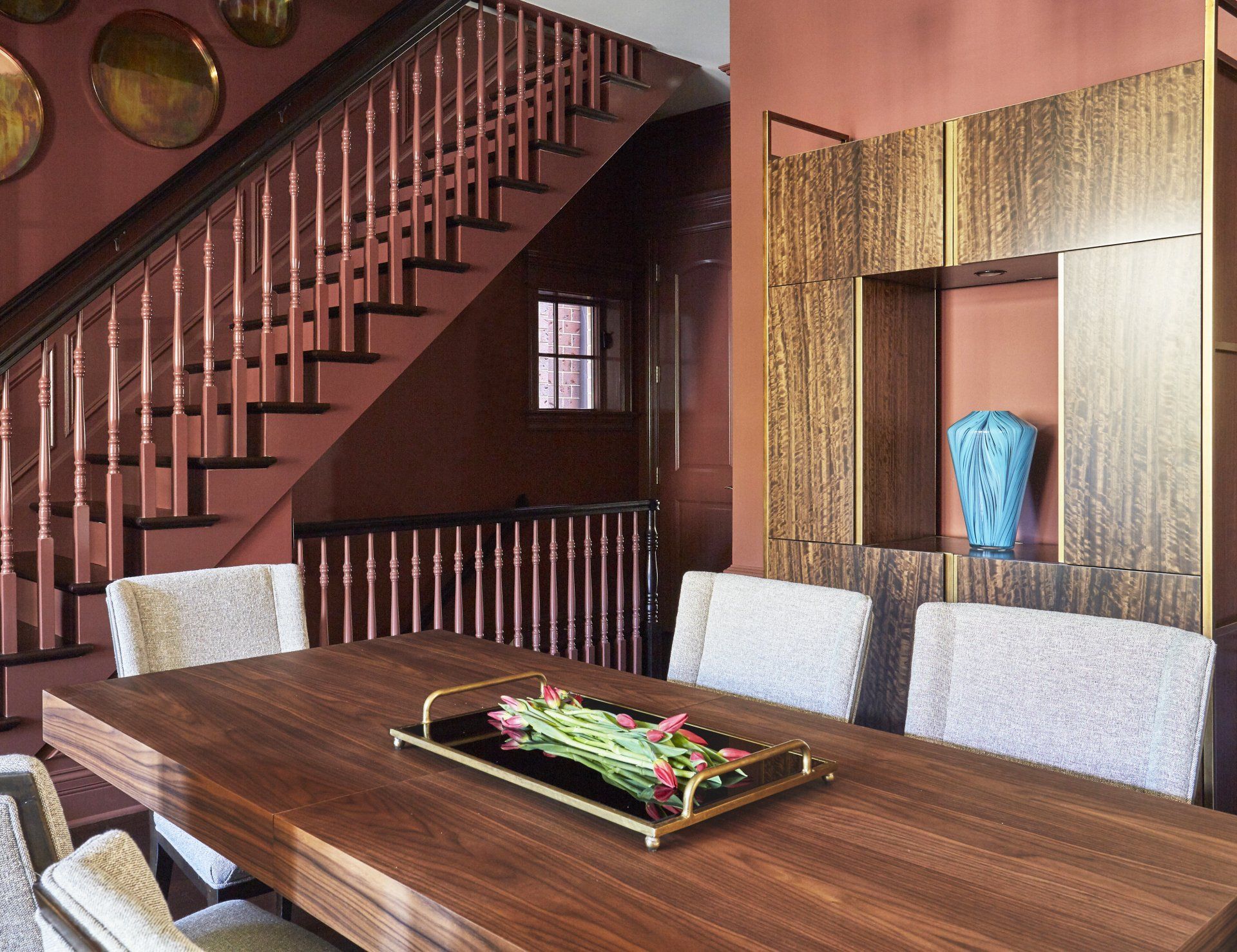 A dining room table with a tray of flowers on it