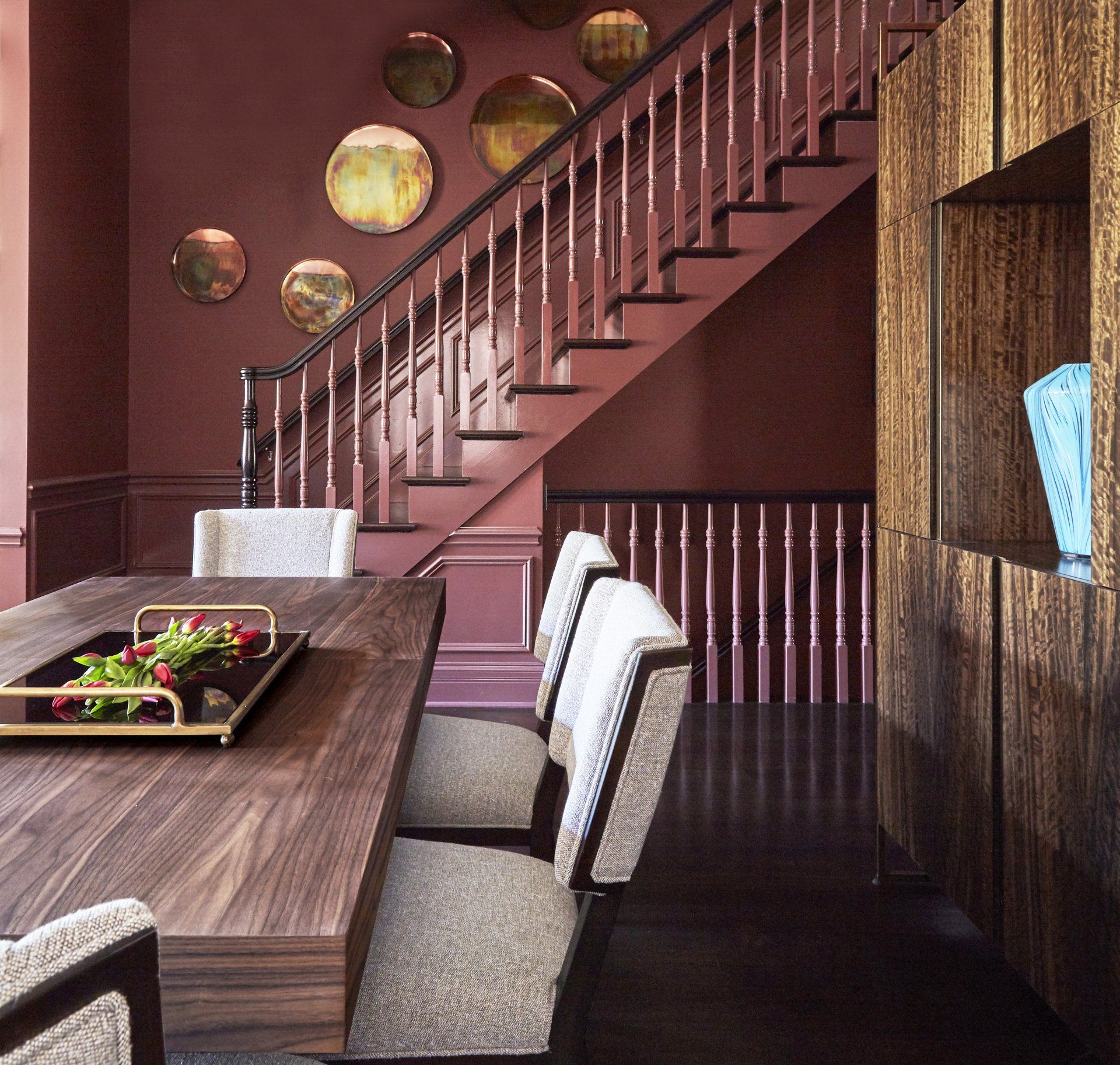 A dining room with a table and chairs and a staircase