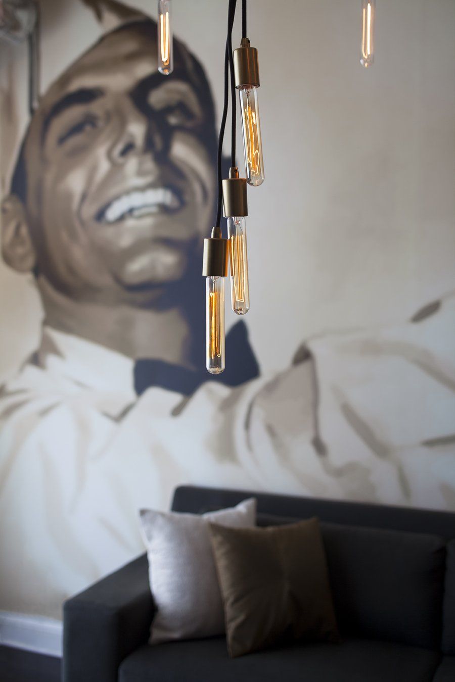 A painting of a smiling chef is behind a couch