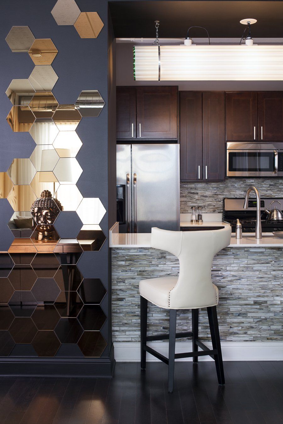 A kitchen with a stainless steel refrigerator and a white chair