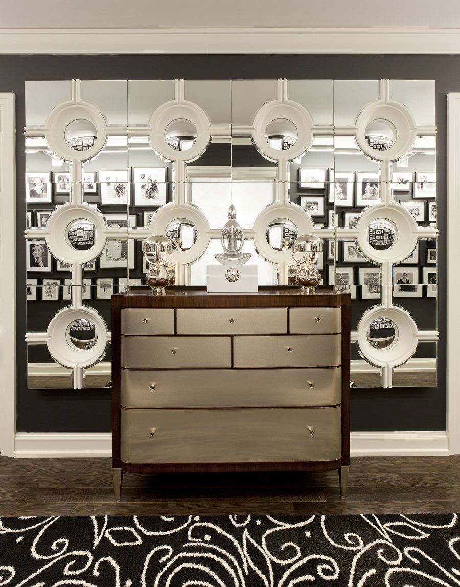 A dresser in front of a wall with pictures on it