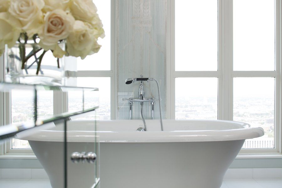 A bathroom with a bathtub and a vase of flowers