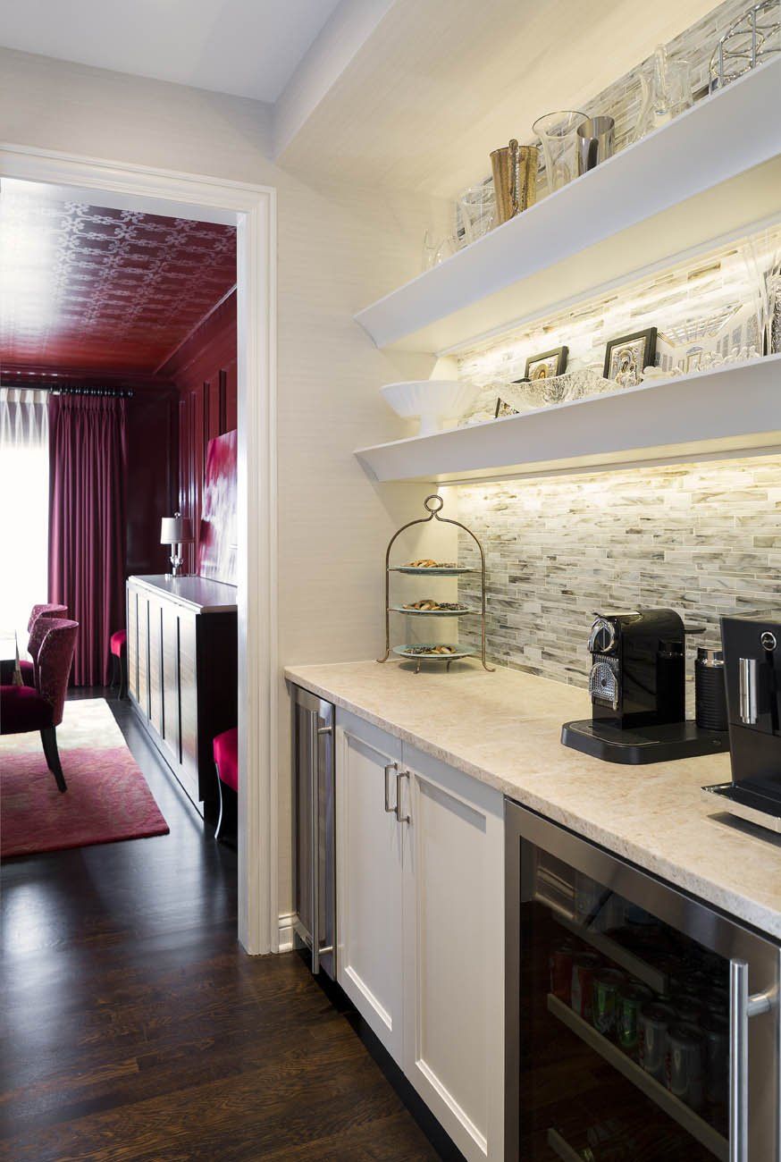 A kitchen with white cabinets and a stainless steel refrigerator