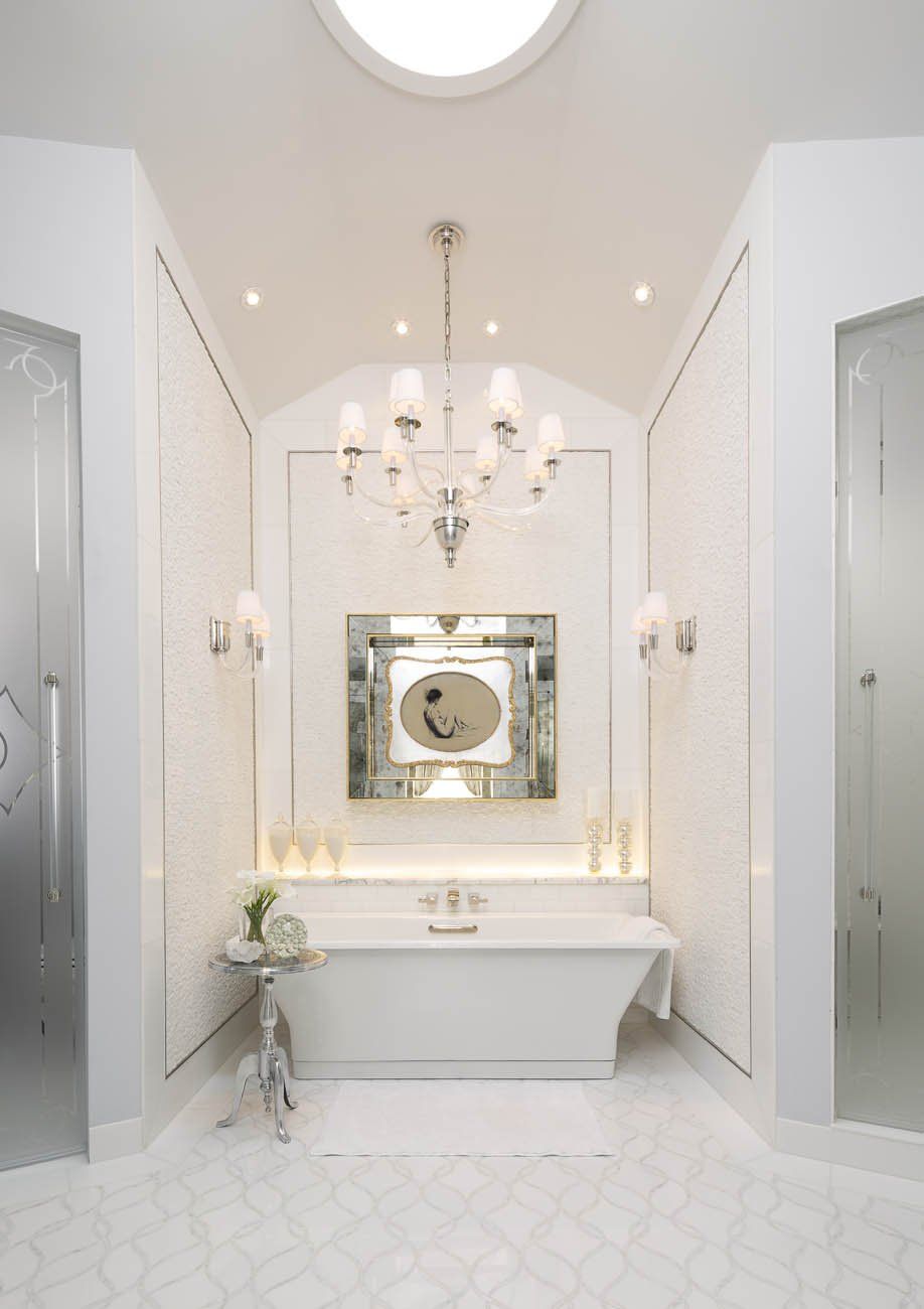 A bathroom with a tub and a chandelier hanging from the ceiling.
