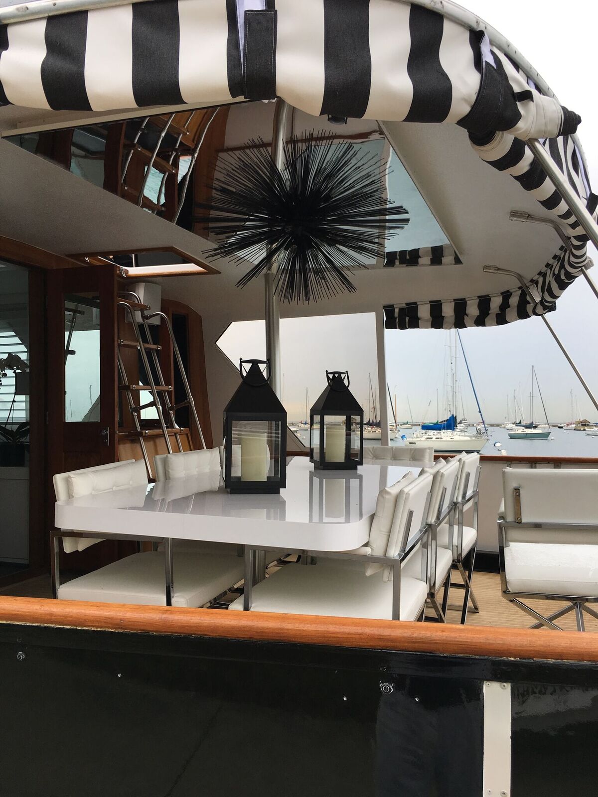 A black and white striped awning over a table with lanterns on it