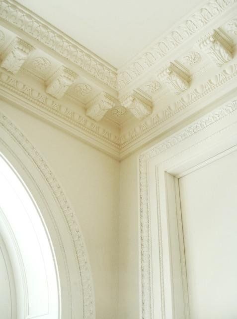 A corner of a room with white walls and molding