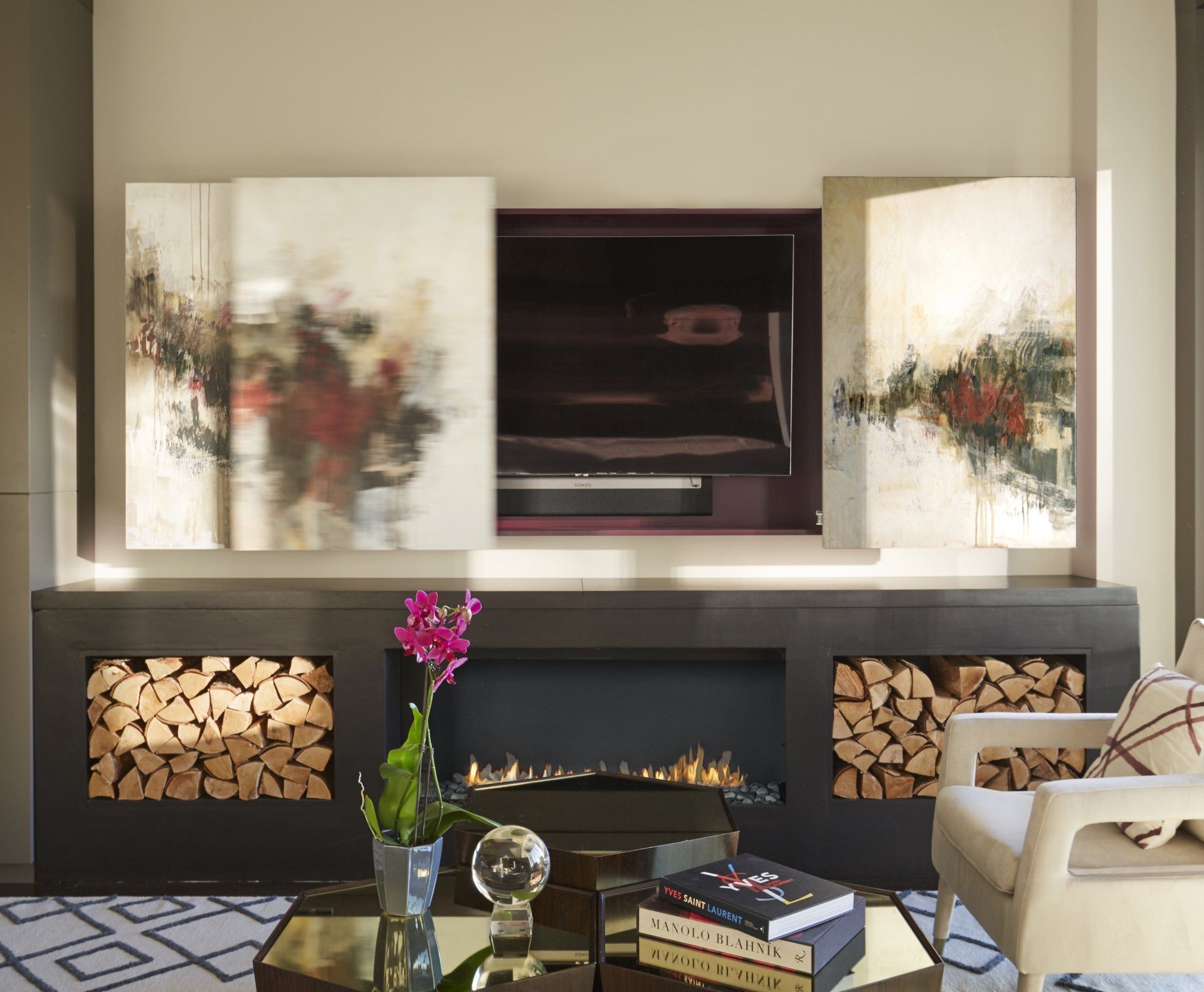 A living room with a fireplace and paintings on the wall