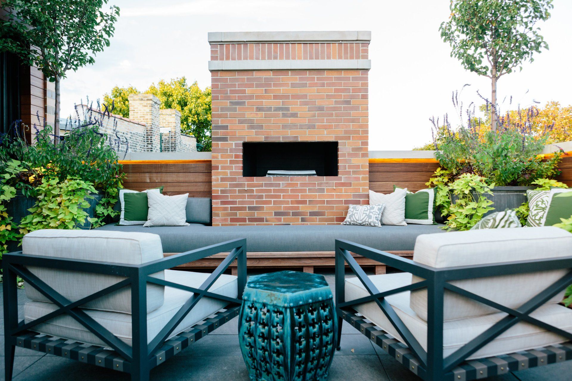 There is a brick fireplace in the middle of the patio.