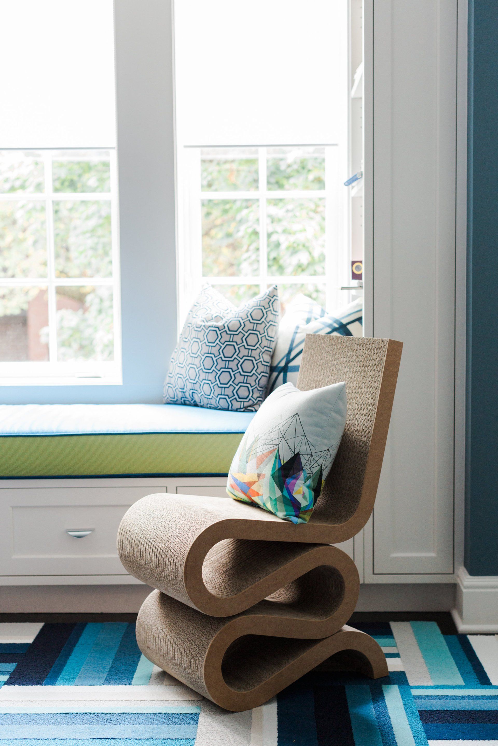 A chair is sitting in a window seat next to a window.