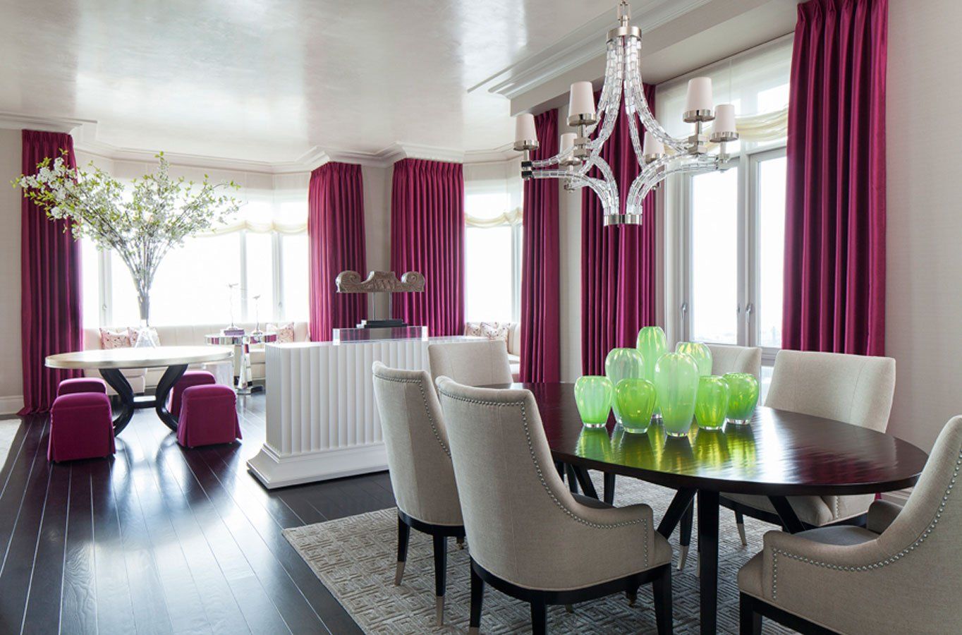 A dining room with a table and chairs and purple curtains