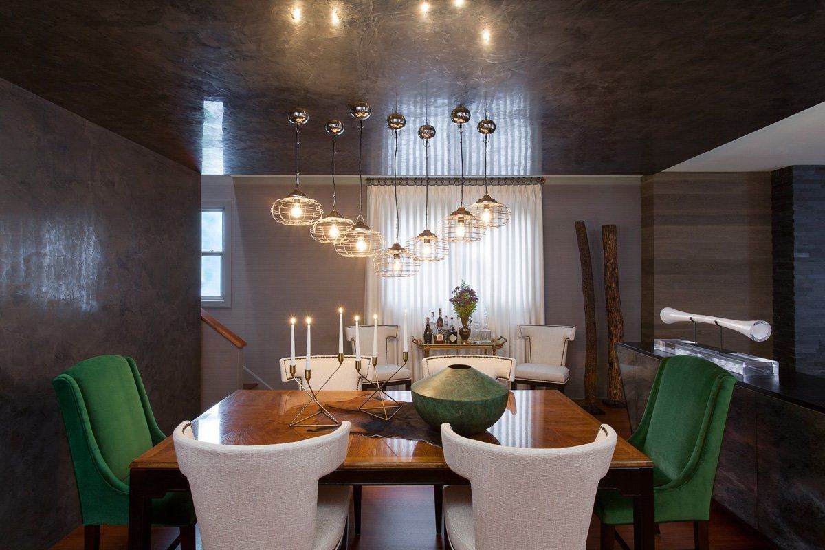A dining room with a wooden table and green chairs