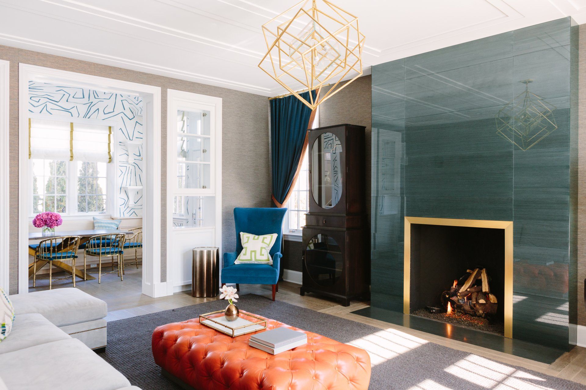 A living room with a fireplace , couch , chair and ottoman.
