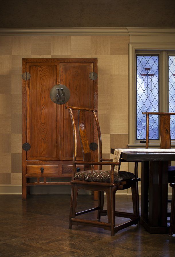 A wooden chair is sitting in front of a table in a room.