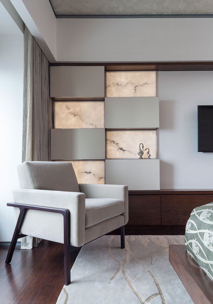 A living room with a chair and a tv on the wall