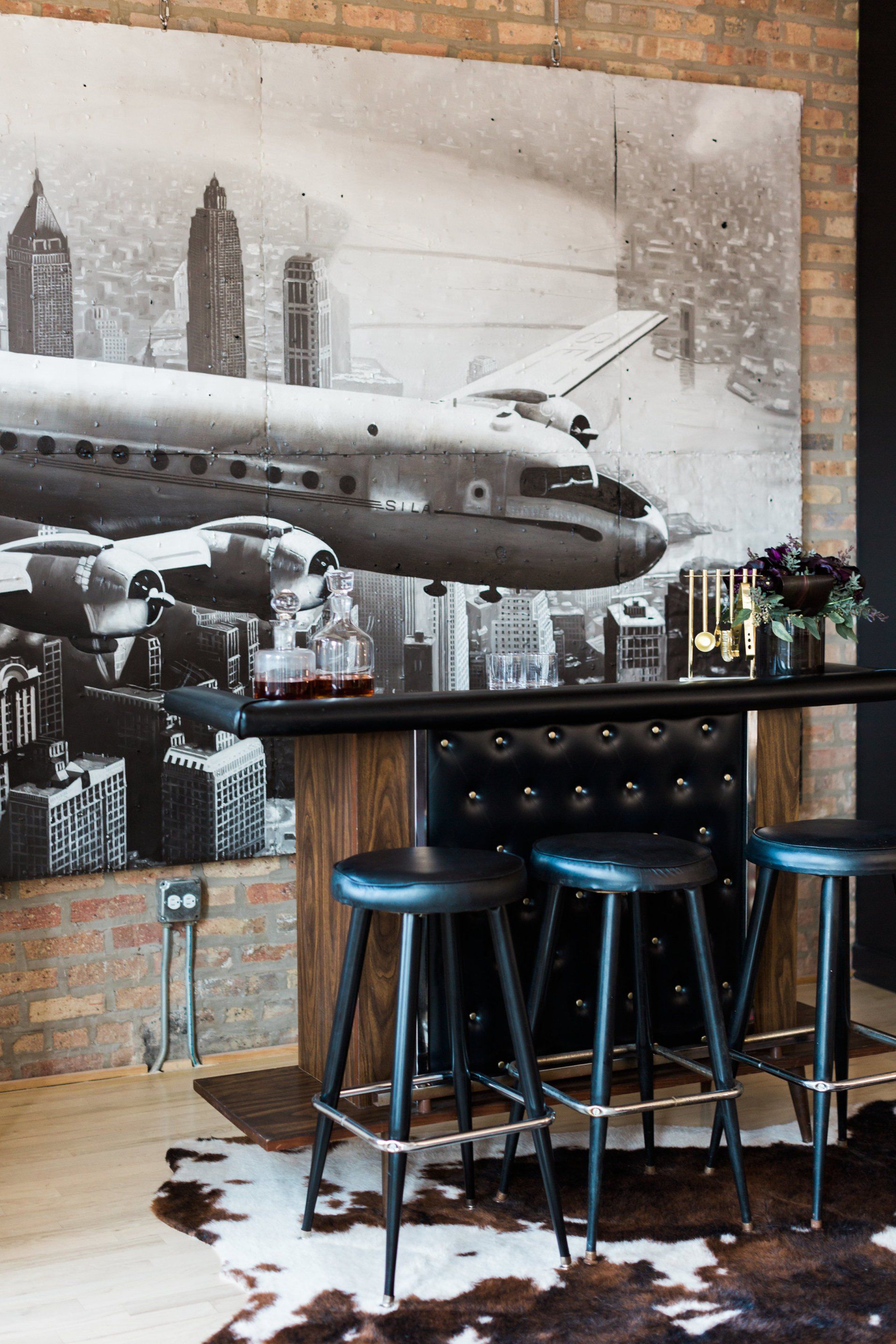 A black and white photo of an airplane flying over a city
