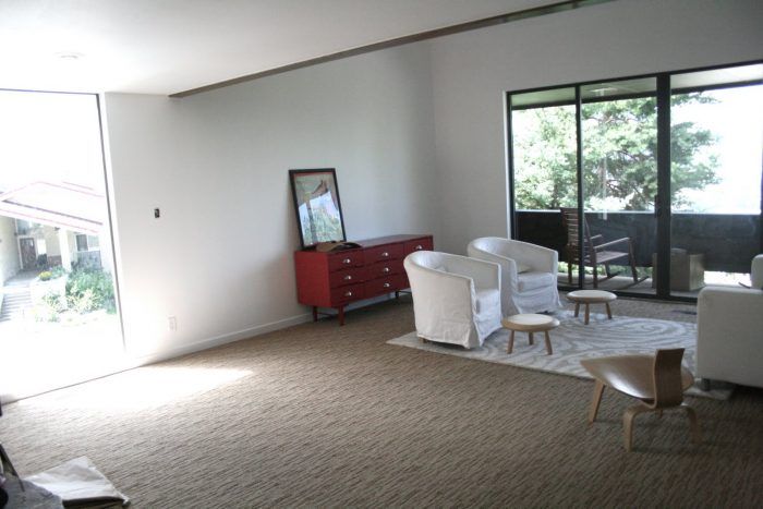 A living room with chairs and a red dresser