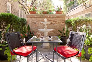 A patio with a table and chairs and a fountain in the background.