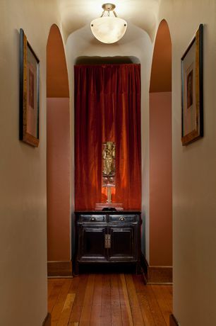 A hallway with wooden floors and a red curtain on the wall.
