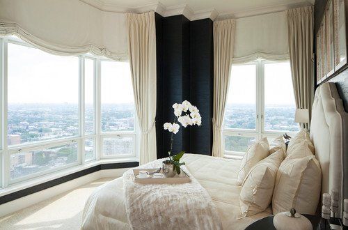 A bedroom with a large bed and a view of the city