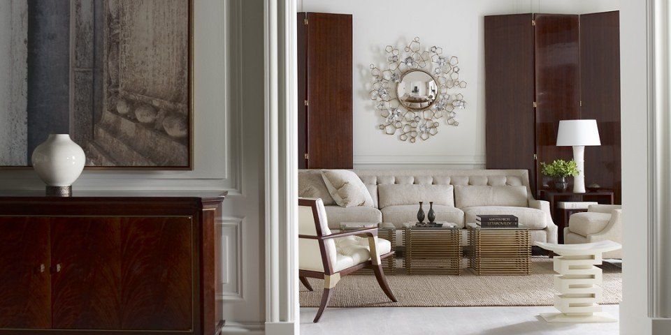 A living room with a couch , chairs , a table and a mirror.
