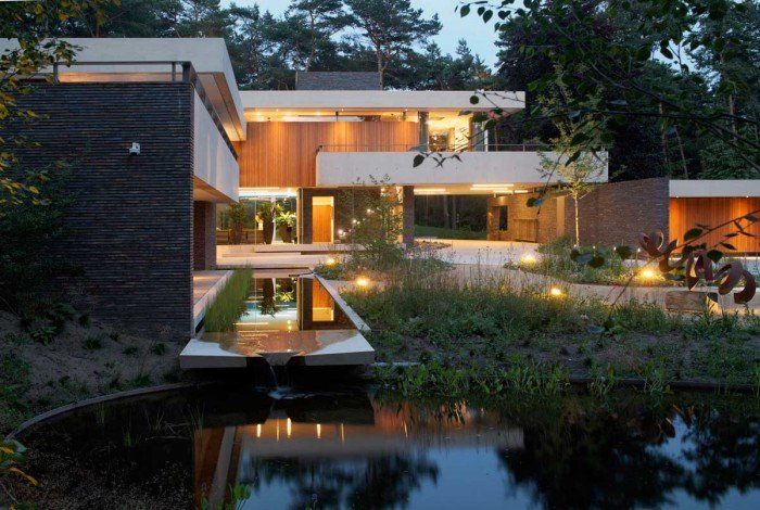 A modern house with a pond in front of it