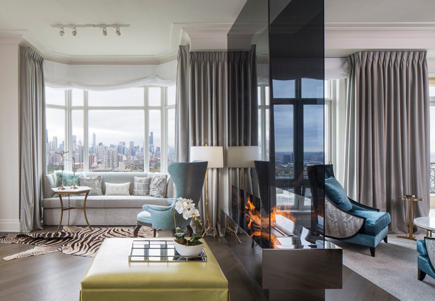 A living room with a fireplace and a view of the city