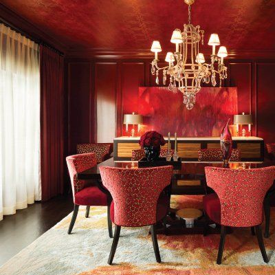 A dining room with red chairs and a chandelier