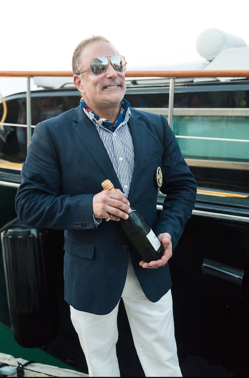 A man in a suit is holding a bottle of champagne