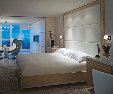 A bedroom with a large bed and a chair