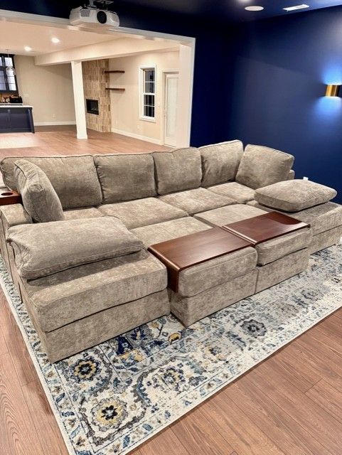 A large sectional couch is sitting on top of a rug in a living room.