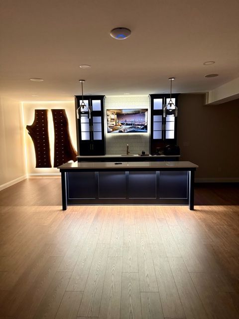An empty room with a bar and a television on the wall