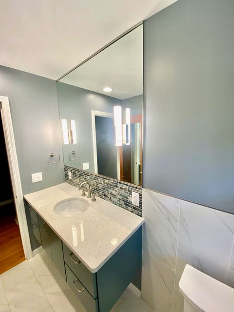 A bathroom with a sink , mirror and toilet.
