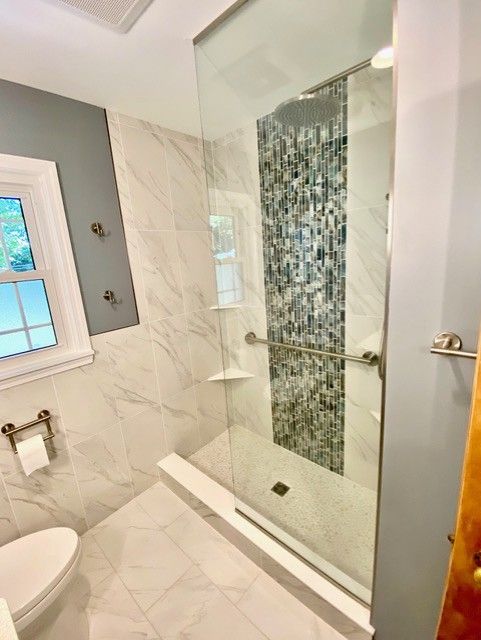 A bathroom with a walk in shower and a toilet