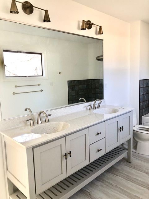 A bathroom with two sinks and a toilet