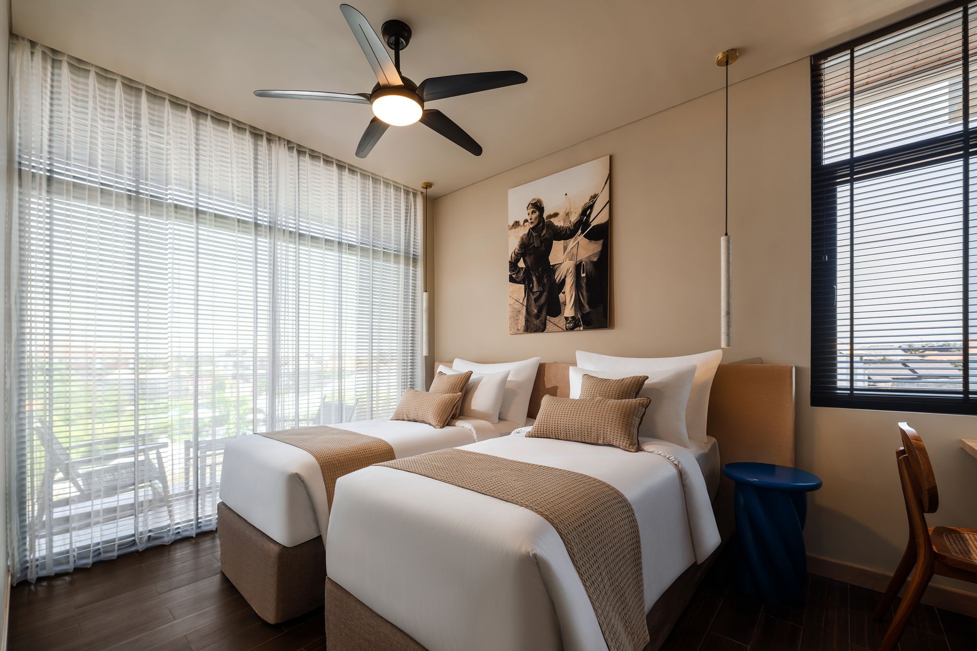 A hotel room with two beds and a ceiling fan.