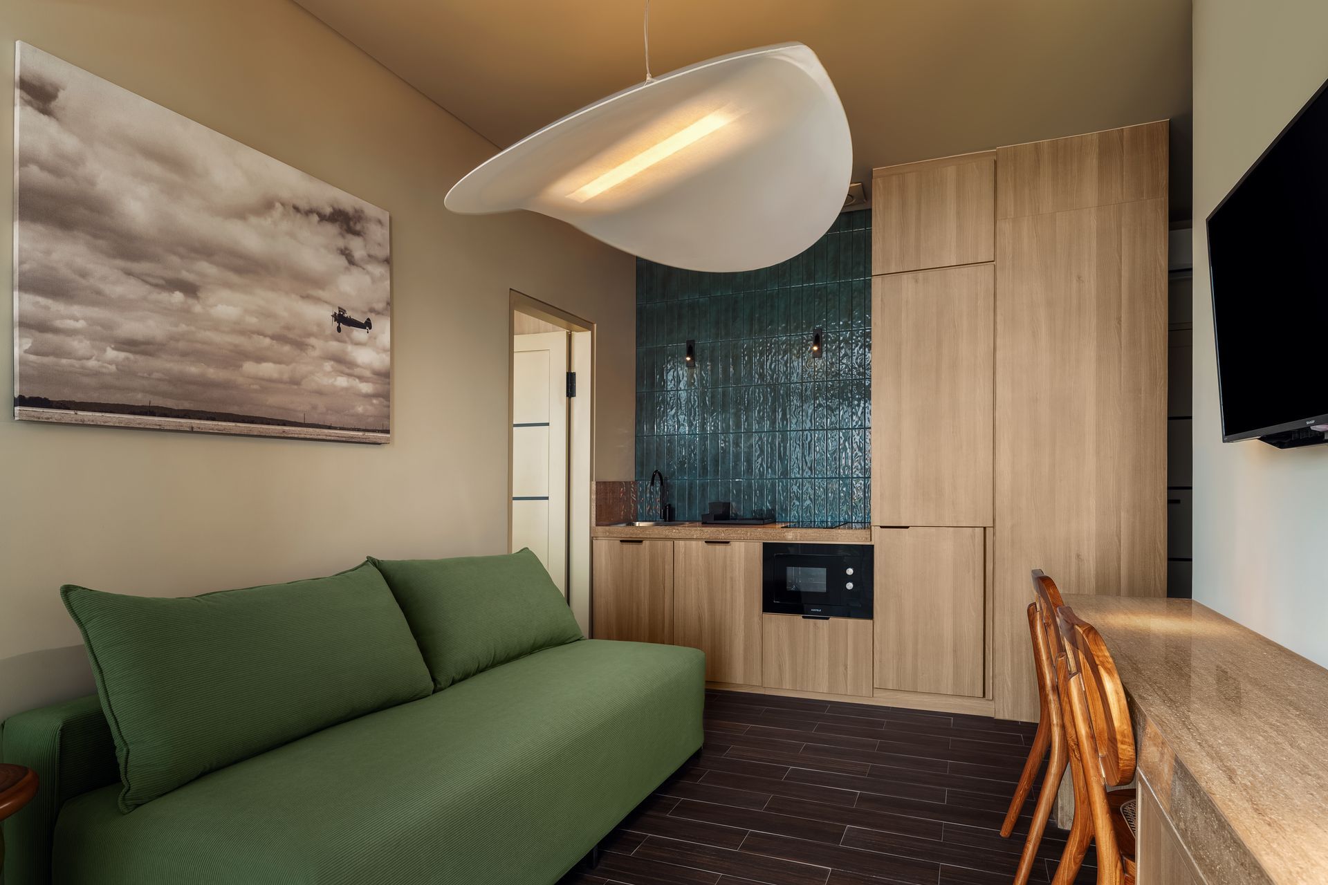 A living room with a green couch and a television