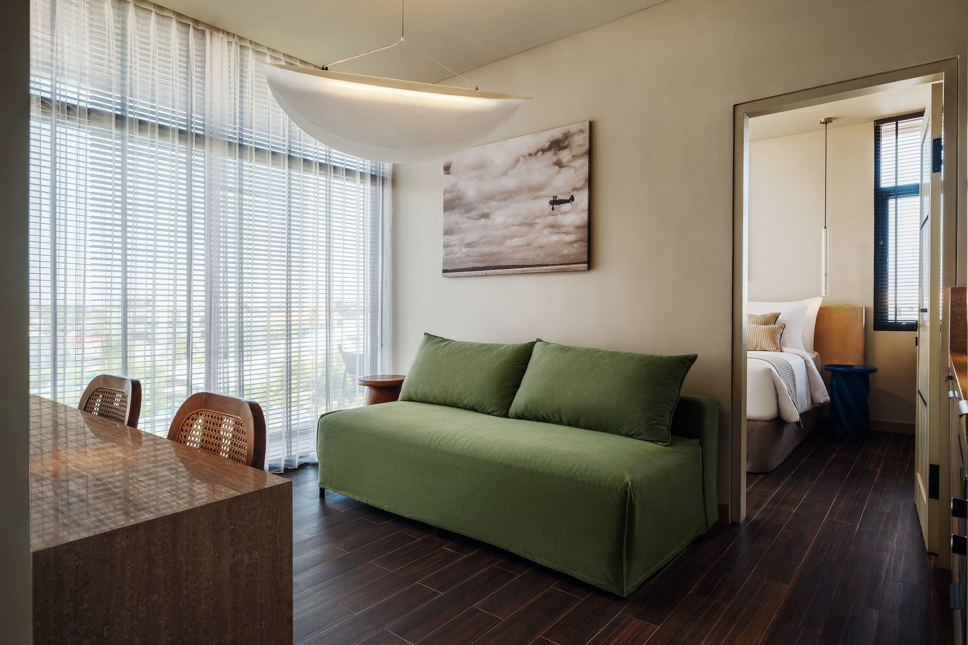 A living room with a green couch and a large window