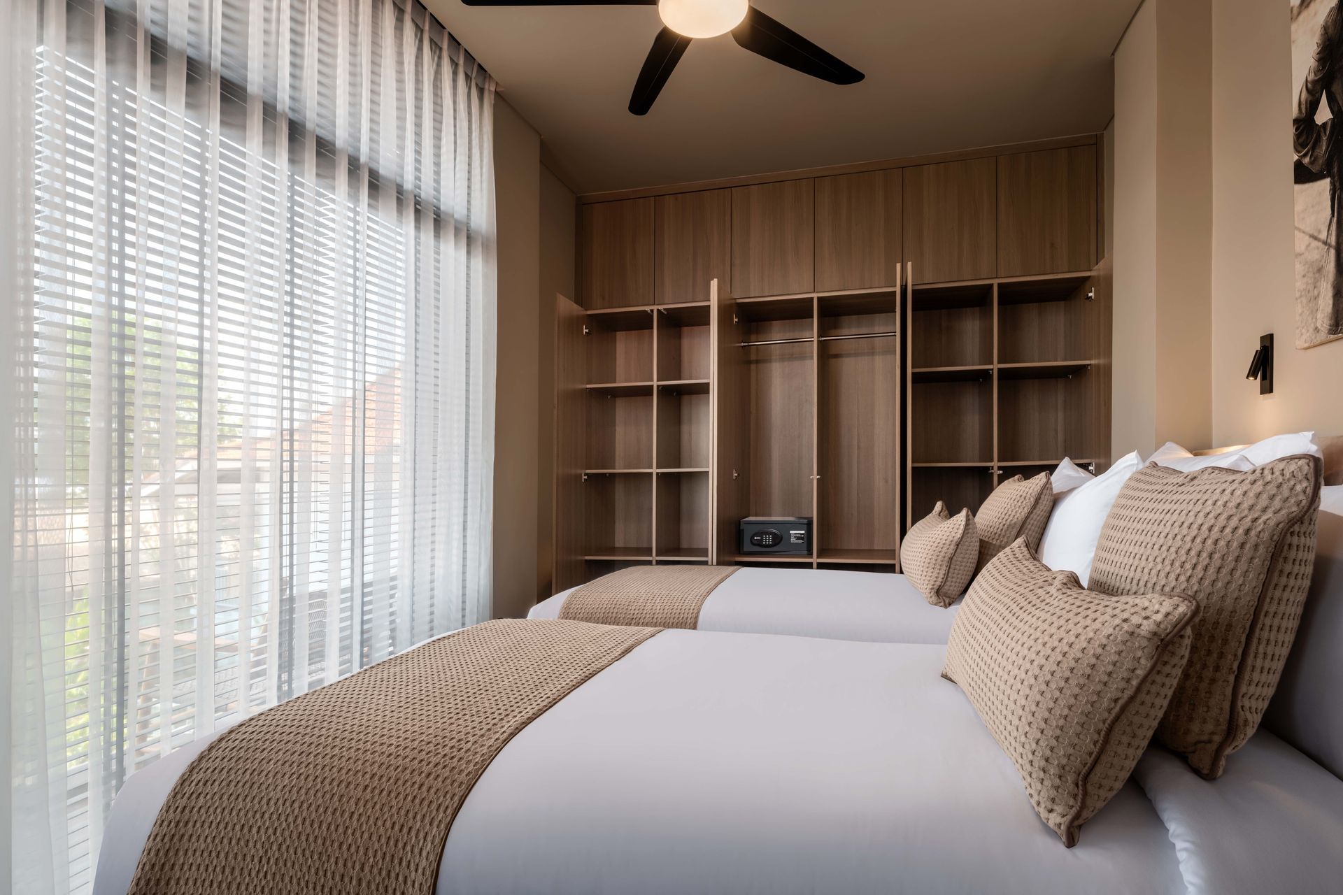 A bedroom with two beds and a ceiling fan.