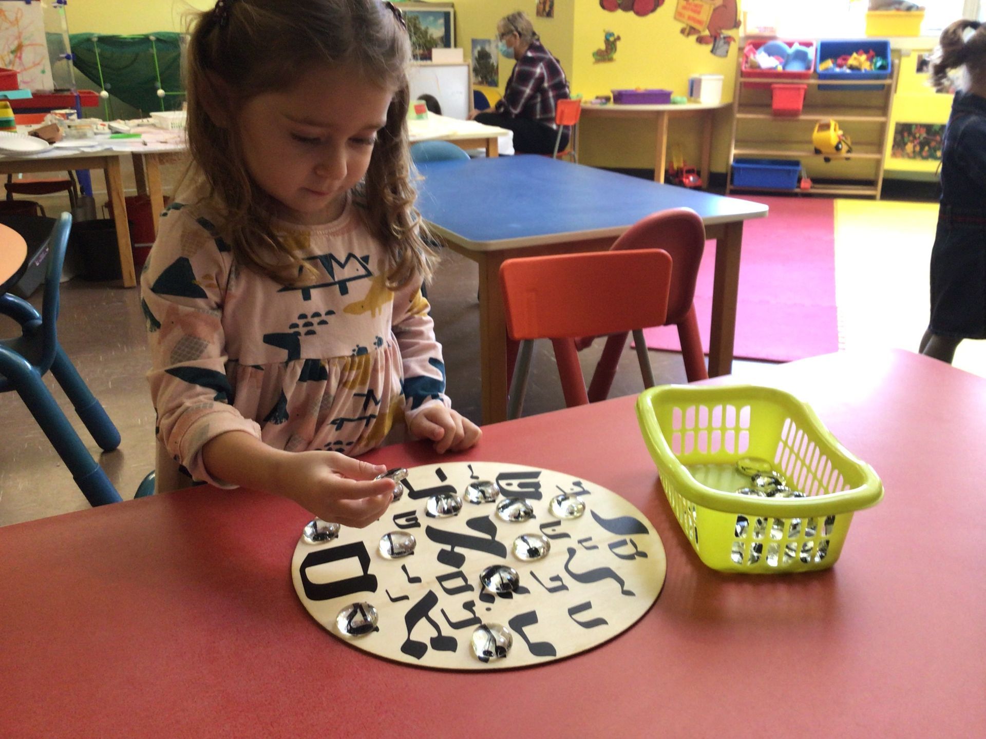 A little girl is playing with a circle with numbers on it