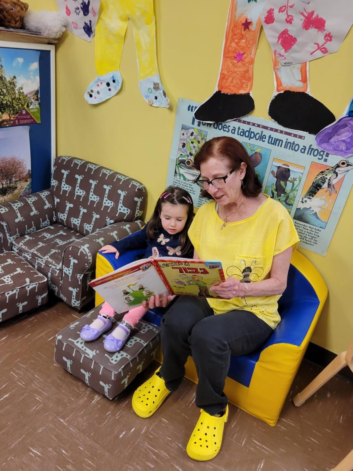 A woman is reading a book to a little girl