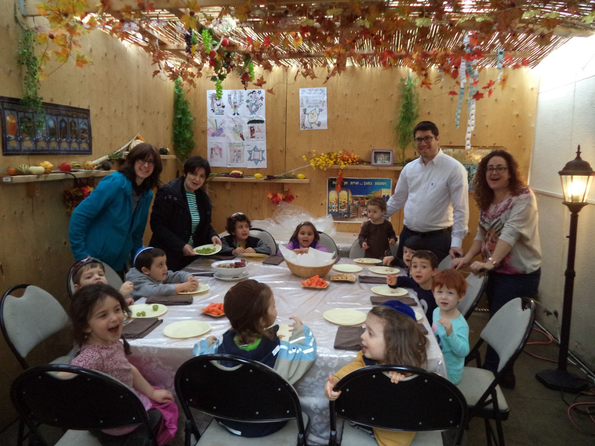 A group of people are standing around a table with plates of food.