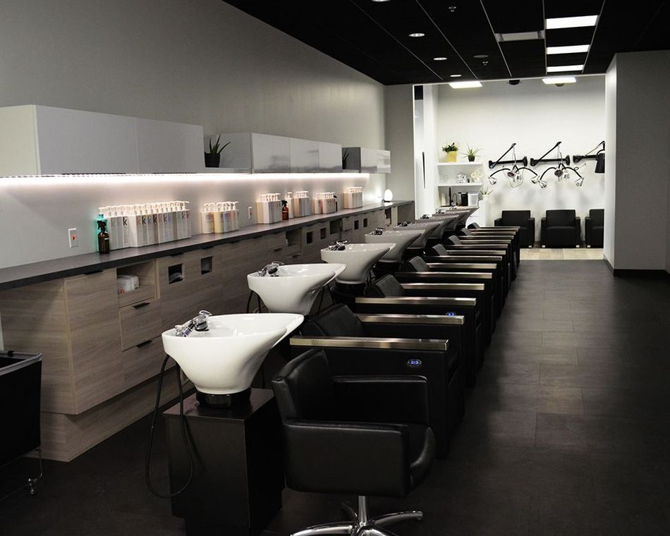 Hair salon interior with wash stations, chairs, and styling products.