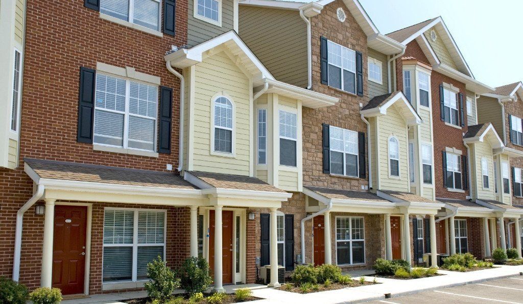 A row of brick apartment buildings with a lot of windows
